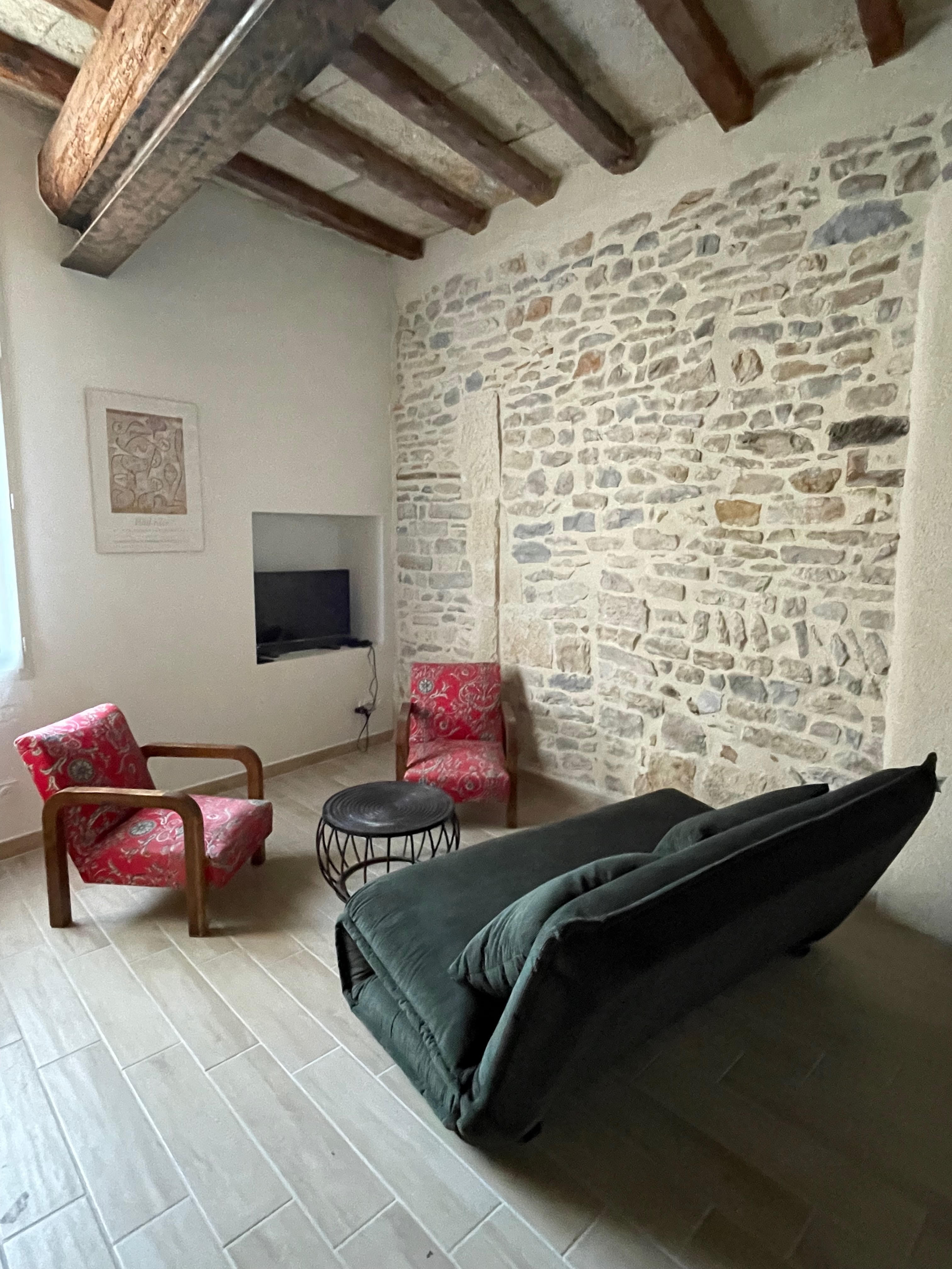 Salon avec mur en pierres apparentes et fauteuils